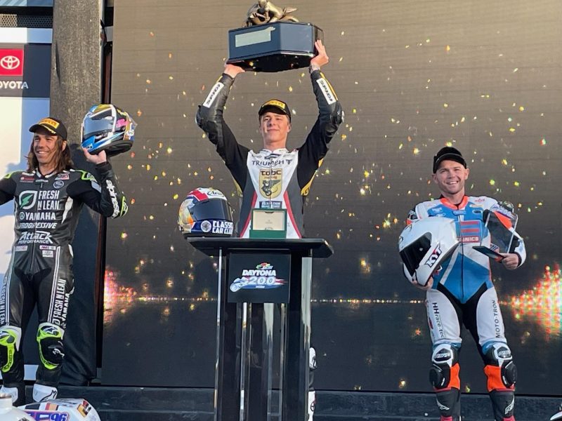 Brandon Paasch (center), raises his first place Daytona 200 trophy as second place rider Cameron Petersen (left) and third place rider Sheridan Morais also celebrate in Ruoff Victory Lane at Daytona International Speedway Saturday, March 11, 2022.